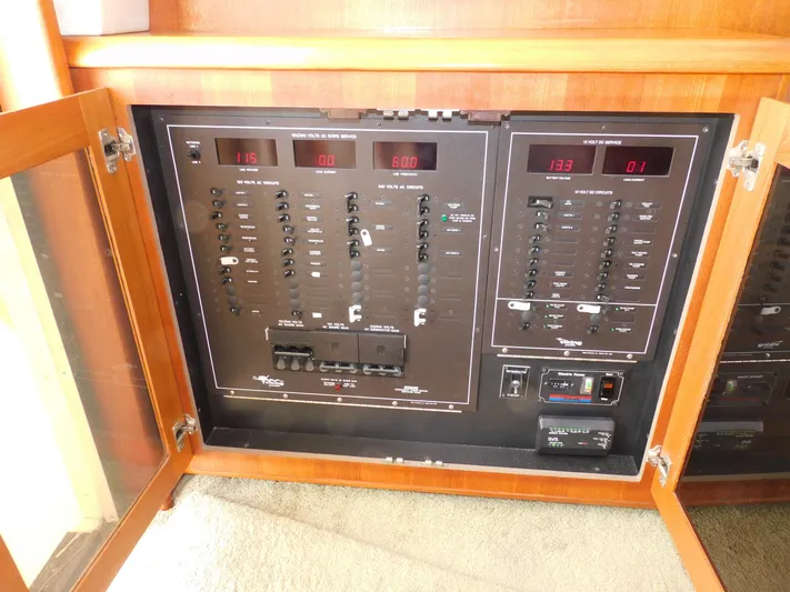 Miss Approach Yacht Photos Pics Electrical panel of 1991 Viking 45' Convertible yacht with open wooden cabinet doors.