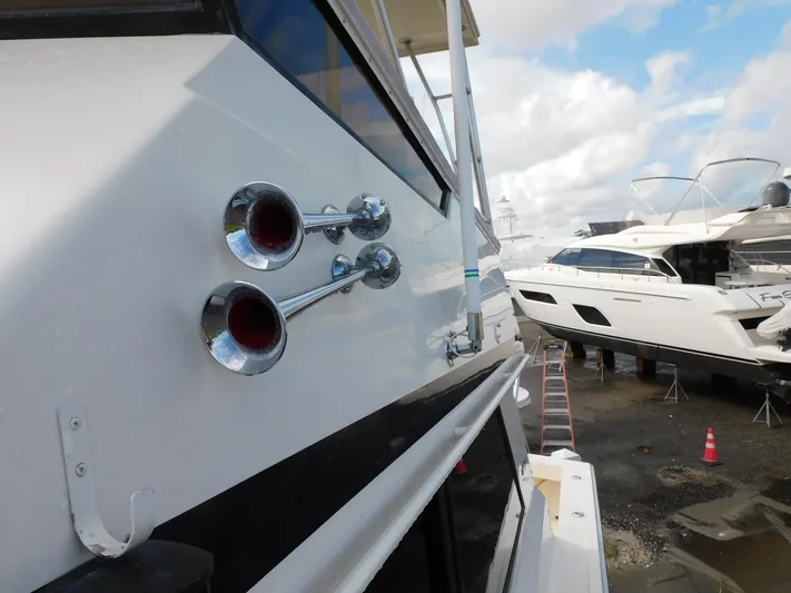 Miss Approach Yacht Photos Pics 1991 Viking 45' Convertible yacht with chrome horns, docked under cloudy skies.