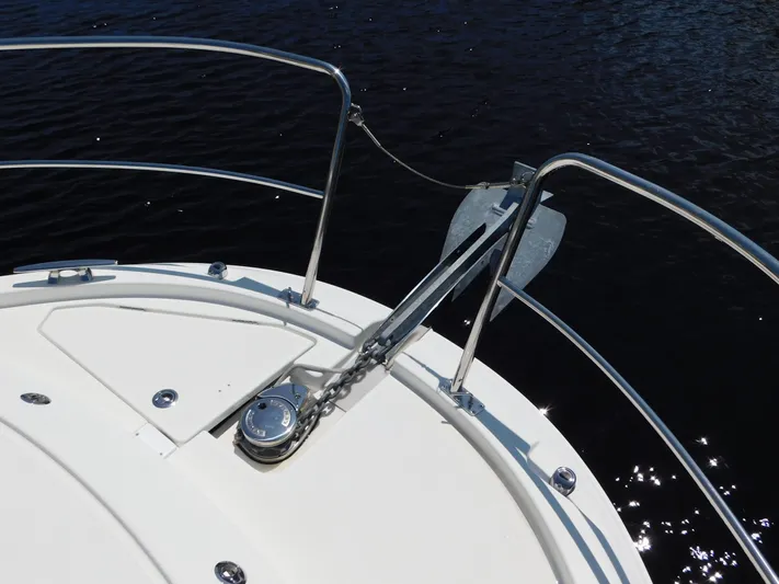  Yacht Photos Pics Bow of 2021 Jeanneau NC 1095 with anchor and railing over water.