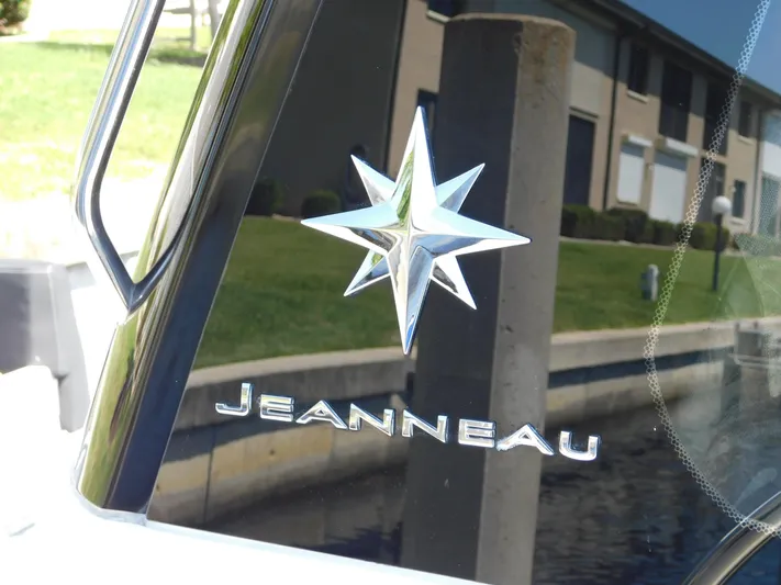  Yacht Photos Pics Jeanneau NC 1095 2021 logo on boat window, reflecting outdoor scenery.