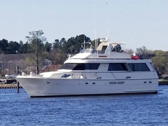  Yacht Photos Pics 1988 Hatteras 60 Motor Yacht on calm water, surrounded by trees.