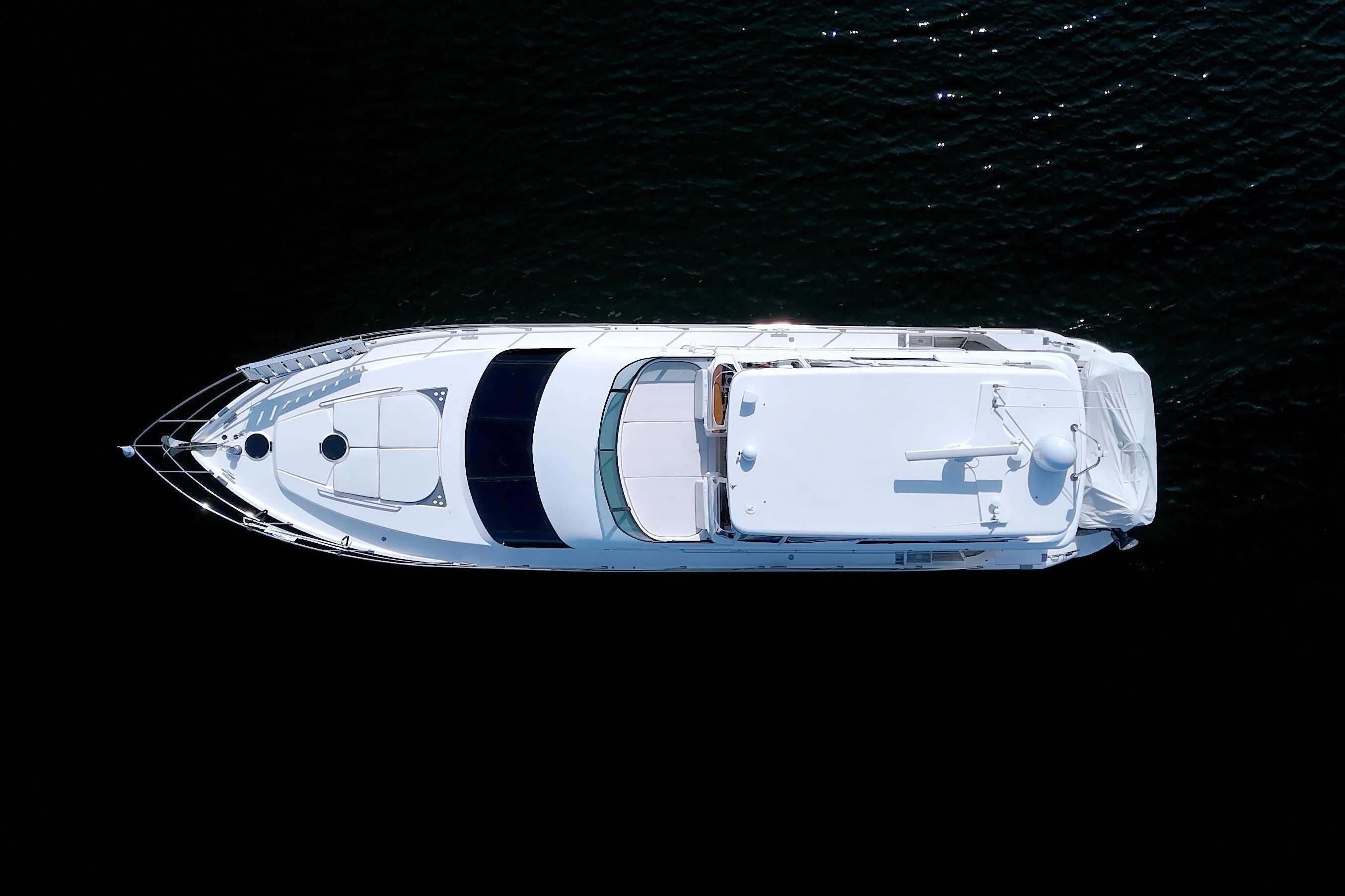 Top view of 2005 Neptunus 62 Flybridge yacht on dark water.