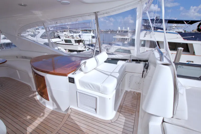 Bliss Yacht Photos Pics Luxurious 2005 Neptunus 62 Flybridge yacht interior with wooden and white seating.