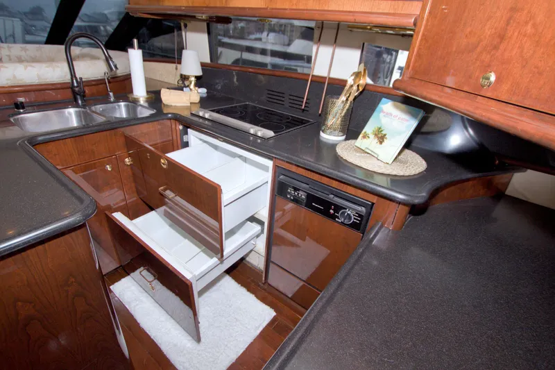 Bliss Yacht Photos Pics Luxurious 2005 Neptunus 62 Flybridge yacht kitchen with wood cabinetry and modern appliances.