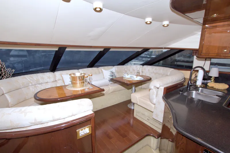 Bliss Yacht Photos Pics Luxurious interior of 2005 Neptunus 62 Flybridge yacht with elegant seating and dining area.