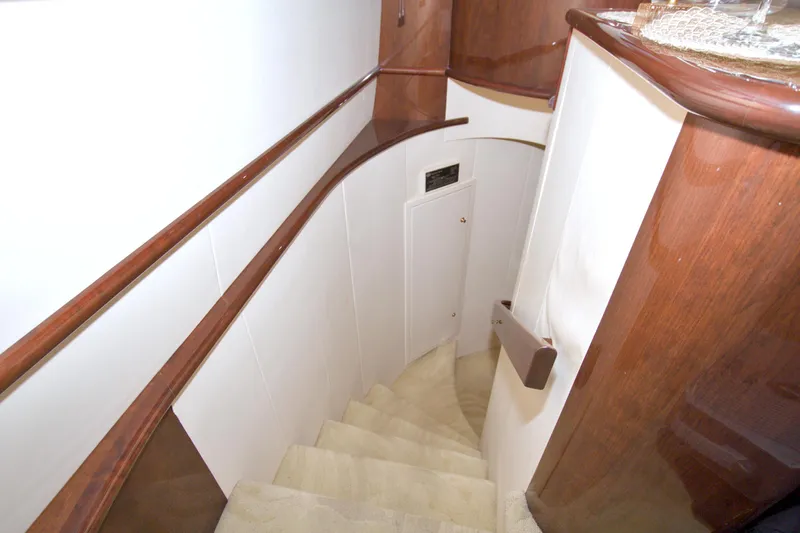 Bliss Yacht Photos Pics Interior staircase of 2005 Neptunus 62 Flybridge yacht with elegant wood finish.