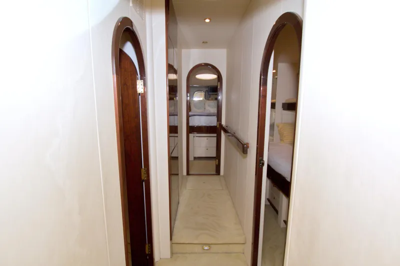 Bliss Yacht Photos Pics Interior hallway of 2005 Neptunus 62 Flybridge yacht with wooden doors and white walls.