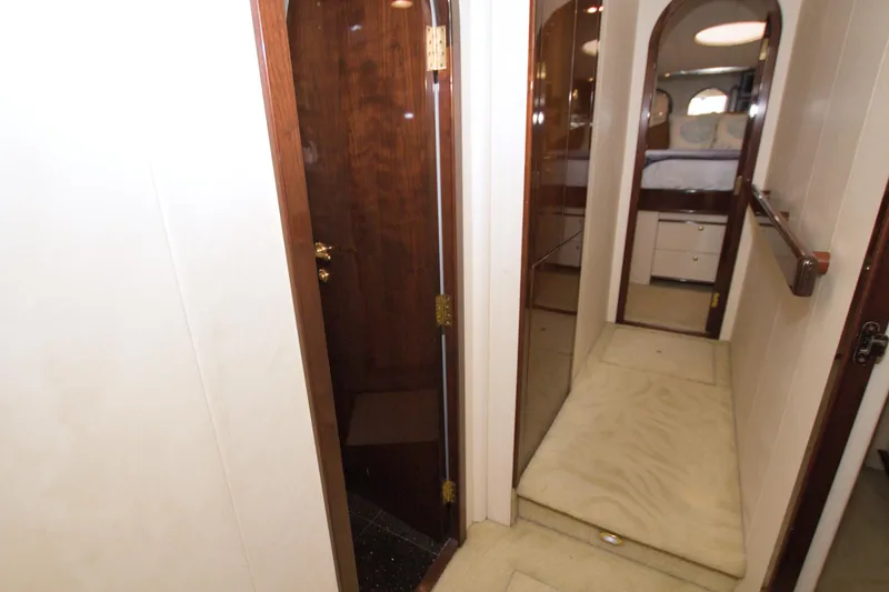 Bliss Yacht Photos Pics Interior hallway of 2005 Neptunus 62 Flybridge yacht with wood accents and carpeted floor.