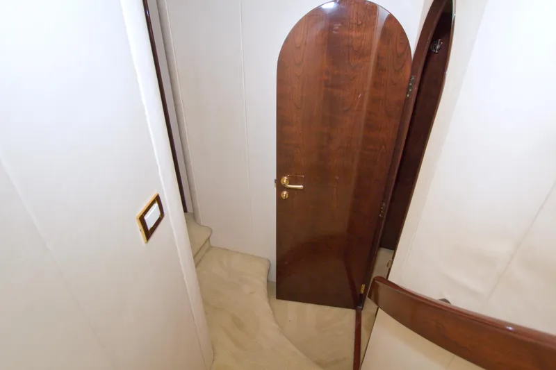 Bliss Yacht Photos Pics Interior of 2005 Neptunus 62 Flybridge yacht with wooden door and beige carpeted stairs.