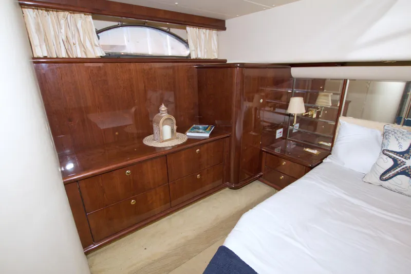 Bliss Yacht Photos Pics Luxurious 2005 Neptunus 62 Flybridge yacht bedroom with elegant wood cabinetry and cozy bedding.