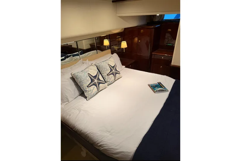 Bliss Yacht Photos Pics Luxurious bedroom interior of 2005 Neptunus 62 Flybridge yacht with starfish-themed pillows.