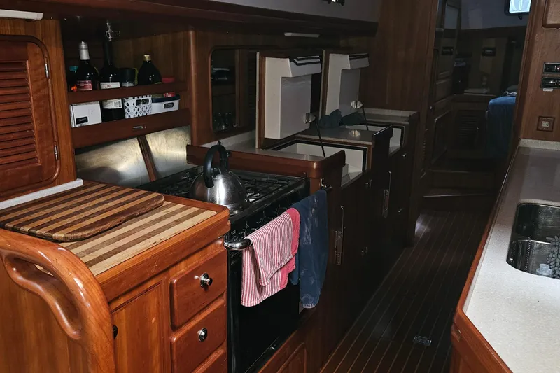 Providence Yacht Photos Pics Interior of 2013 Passport 470 Center Cockpit yacht kitchen with wooden cabinetry and appliances.