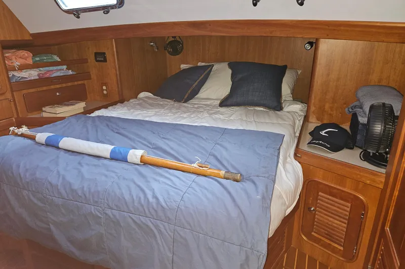 Providence Yacht Photos Pics Cozy cabin interior of 2013 Passport 470 Center Cockpit sailboat with bed and wooden storage.