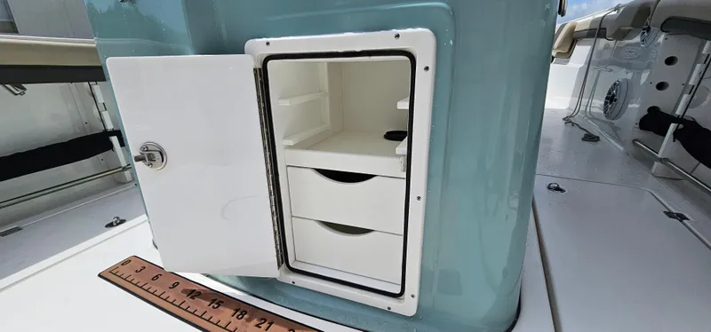  Yacht Photos Pics Open storage compartment on 2022 Tidewater 320 CC Adventure boat with ruler for scale.