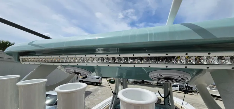  Yacht Photos Pics 2022 Tidewater 320 CC Adventure boat with rod holders and speakers under a blue sky.