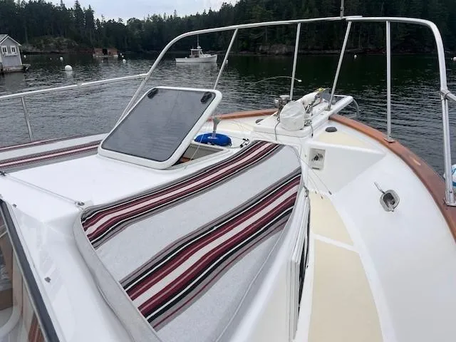 Emily Anne Yacht Photos Pics 2001 Island Gypsy Euro Sedan Trawler on calm water, featuring deck and striped cushion.