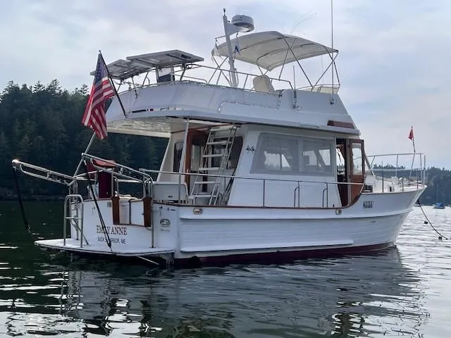 Emily Anne Yacht Photos Pics 2001 Island Gypsy Euro Sedan Trawler on calm water, displaying flags.