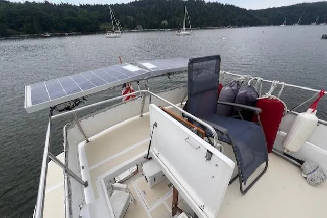 Emily Anne Yacht Photos Pics 2001 Island Gypsy Euro Sedan Trawler with solar panels, docked in a scenic harbor.