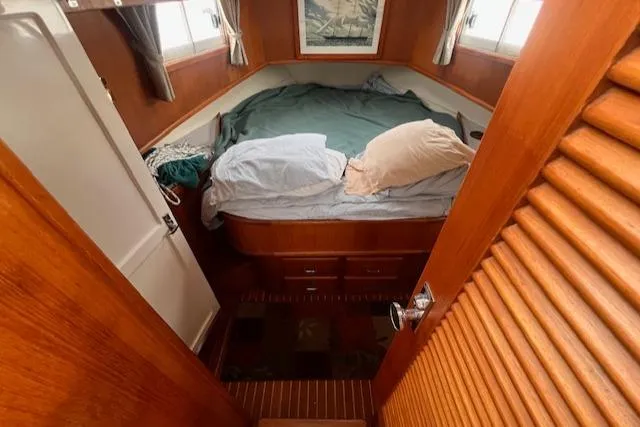 Emily Anne Yacht Photos Pics 2001 Island Gypsy Euro Sedan Trawler cabin with bed, wooden interior, and nautical decor.