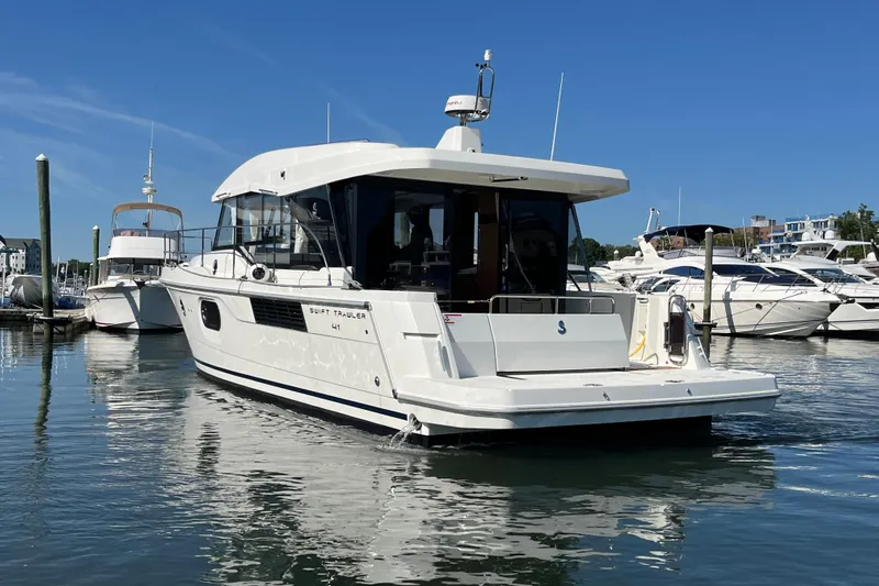  Yacht Photos Pics 2026 Beneteau 41 Swift Trawler Sedan docked in a marina under clear blue skies.