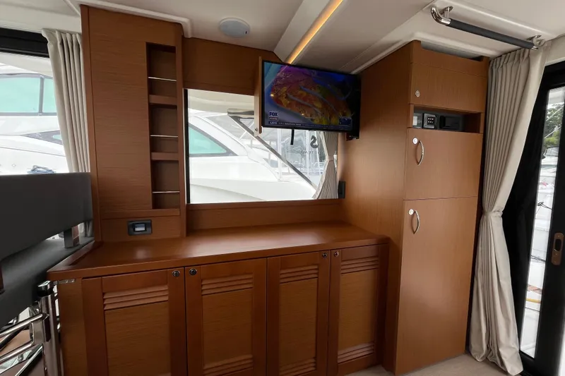 Yacht Photos Pics Interior of 2026 Beneteau 41 Swift Trawler Sedan with wood cabinetry and mounted TV.