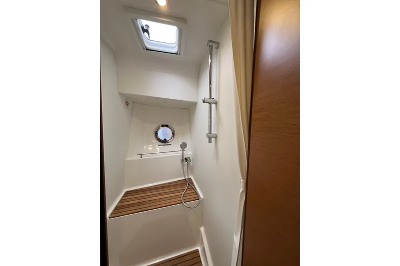  Yacht Photos Pics Shower area in 2026 Beneteau 41 Swift Trawler Sedan with wooden flooring and porthole.