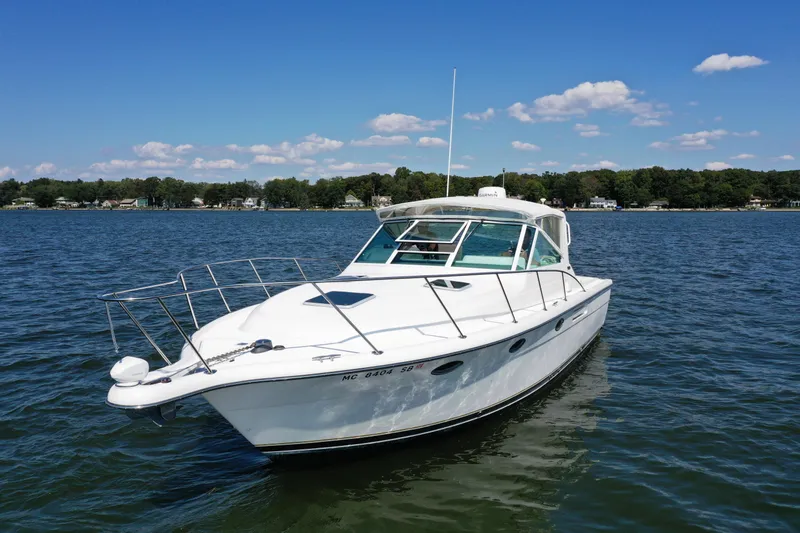  Yacht Photos Pics 2001 Tiara 31 Open boat on a calm lake under a clear blue sky.