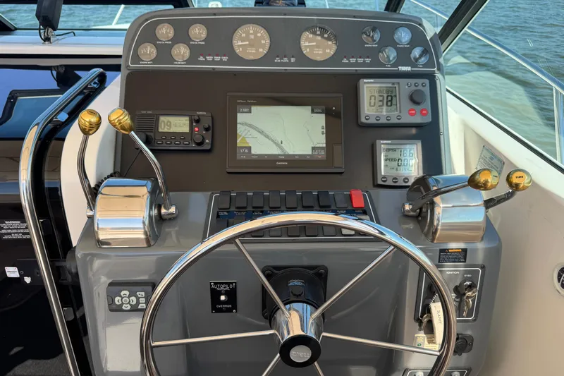  Yacht Photos Pics Control panel of a 2001 Tiara 31 Open boat with steering wheel and navigation instruments.