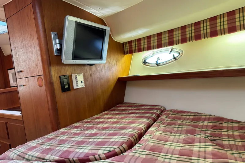  Yacht Photos Pics Interior of 2001 Tiara 31 Open yacht with plaid bedding and wall-mounted TV.
