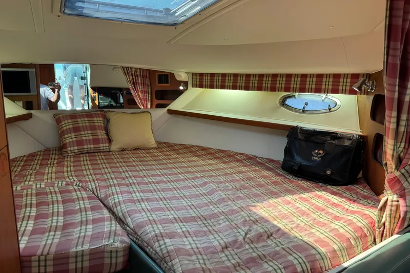  Yacht Photos Pics 2001 Tiara 31 Open cabin with plaid bedding, porthole, and bag.
