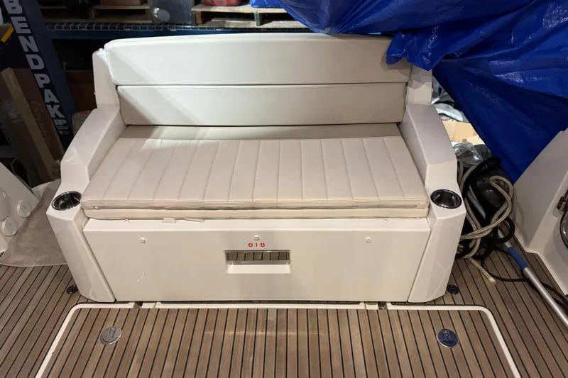  Yacht Photos Pics 2017 Jeanneau NC 9 boat seating area with white cushioned bench and cup holders.