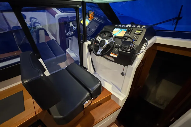  Yacht Photos Pics Interior helm of 2017 Jeanneau NC 9 boat with modern controls and seating.