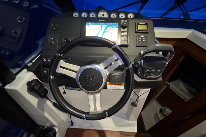  Yacht Photos Pics Steering wheel and dashboard of a 2017 Jeanneau NC 9 boat with navigation controls.