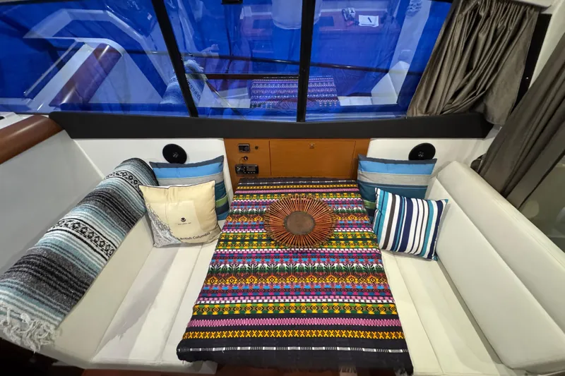  Yacht Photos Pics Interior of 2017 Jeanneau NC 9 with colorful textiles and cushions on seating area.