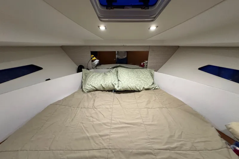  Yacht Photos Pics Cozy cabin interior of 2017 Jeanneau NC 9 with comfortable bedding and ambient lighting.