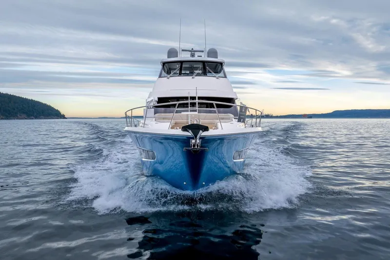 Yacht Photos Pics 2021 Riviera 64 Sports Motor Yacht cruising on open water at sunset.