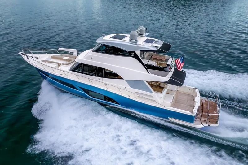  Yacht Photos Pics 2021 Riviera 64 Sports Motor Yacht cruising on open water, showcasing sleek design and luxury.