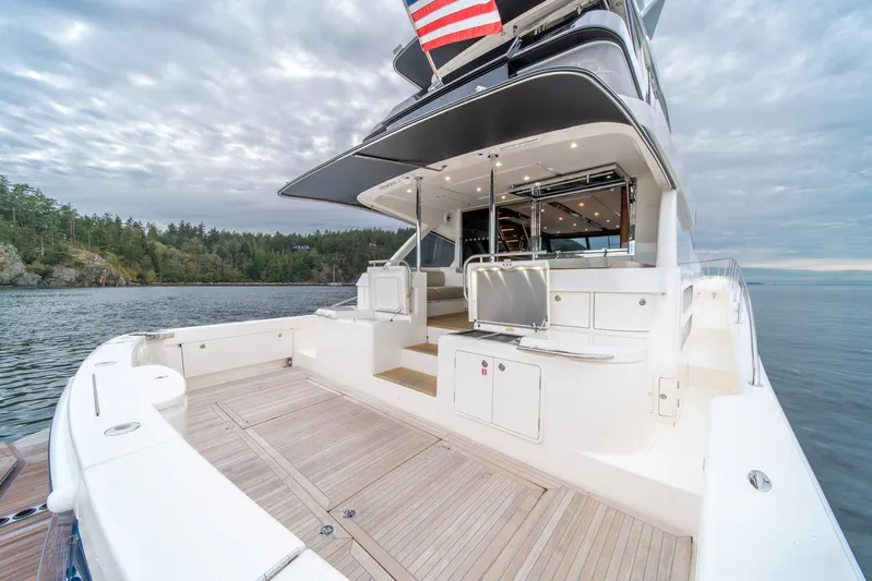  Yacht Photos Pics 2021 Riviera 64 Sports Motor Yacht on serene water with spacious deck and modern design.