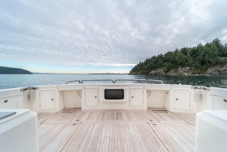  Yacht Photos Pics 2021 Riviera 64 Sports Motor Yacht deck with scenic ocean and forest view.