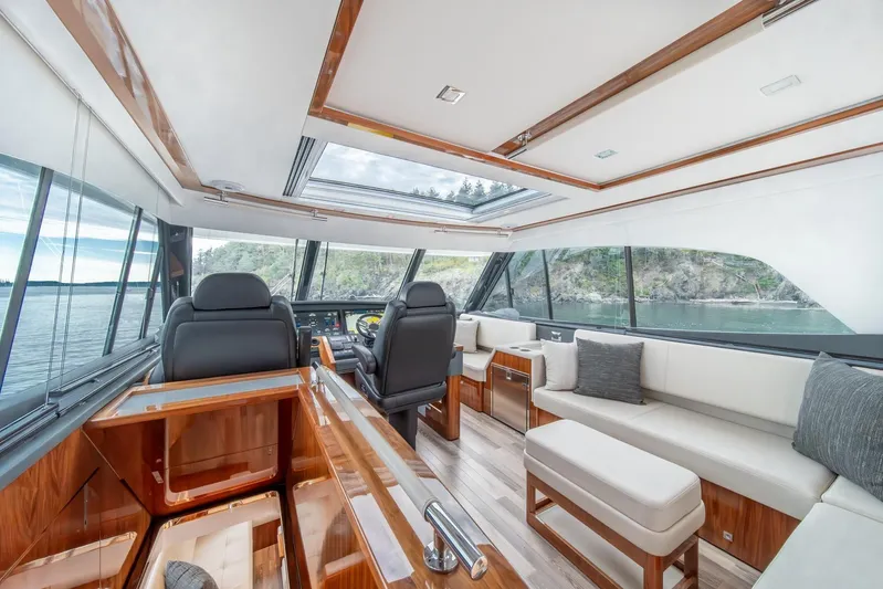  Yacht Photos Pics Luxurious interior of 2021 Riviera 64 Sports Motor Yacht with panoramic windows and plush seating.