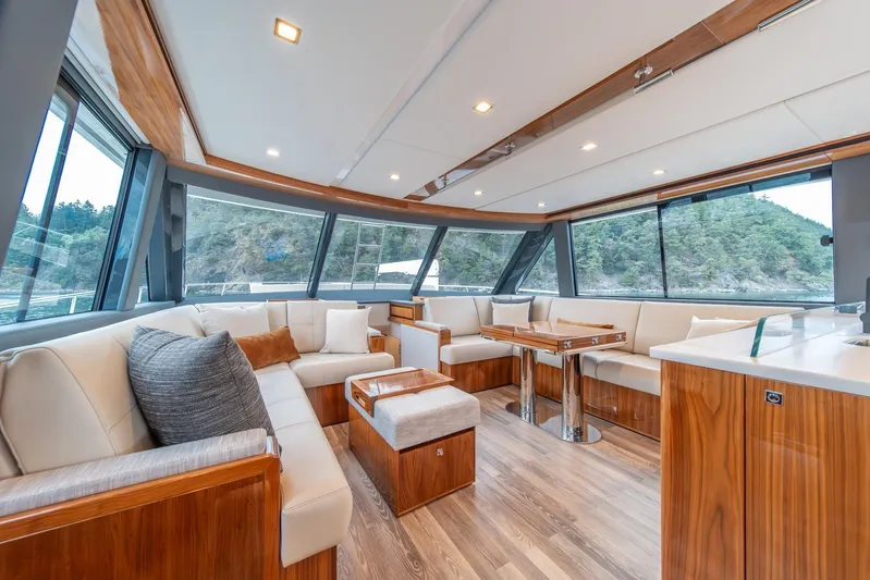  Yacht Photos Pics Luxurious interior of 2021 Riviera 64 Sports Motor Yacht with elegant seating and panoramic windows.