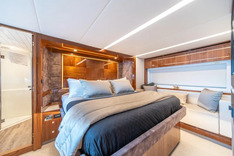  Yacht Photos Pics Luxurious bedroom interior of 2021 Riviera 64 Sports Motor Yacht with elegant wood finishes.