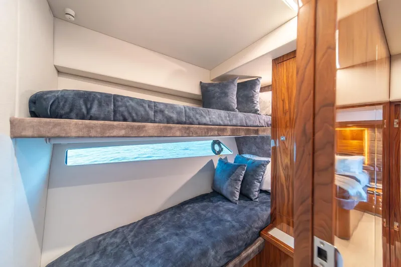  Yacht Photos Pics 2021 Riviera 64 Sports Motor Yacht cabin with bunk beds and ocean view window.