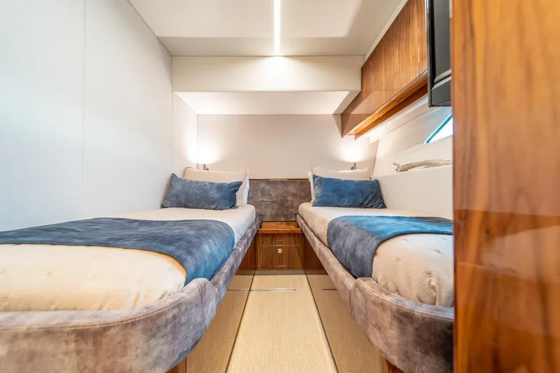  Yacht Photos Pics Luxurious twin cabin in 2021 Riviera 64 Sports Motor Yacht, featuring elegant wood finishes.
