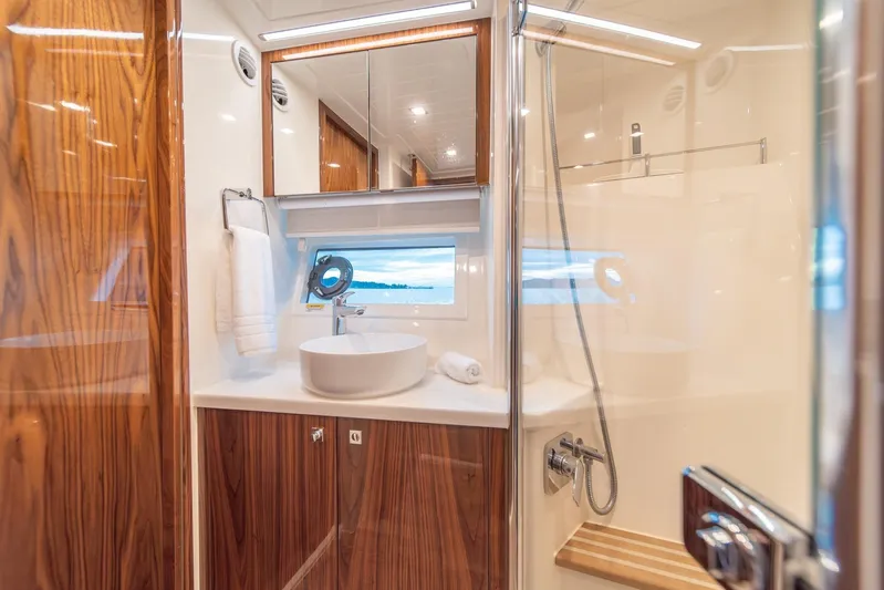  Yacht Photos Pics Luxurious bathroom in 2021 Riviera 64 Sports Motor Yacht with modern fixtures and wood accents.