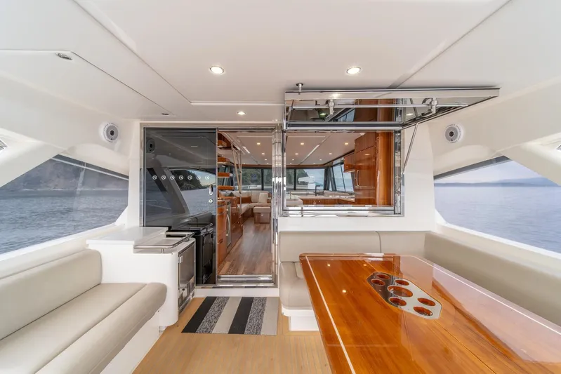  Yacht Photos Pics Luxurious interior of 2021 Riviera 64 Sports Motor Yacht with elegant seating and dining area.