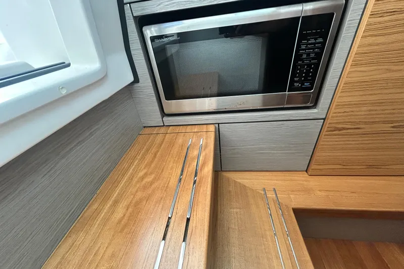  Yacht Photos Pics 2023 Tiara Yachts 38 LS interior with microwave and wooden cabinetry.