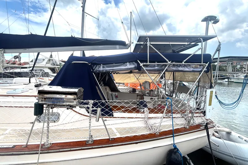 Carpe Diem Yacht Photos Pics 1995 Island Packet 40 sailboat docked, featuring a blue canopy and outdoor grill.