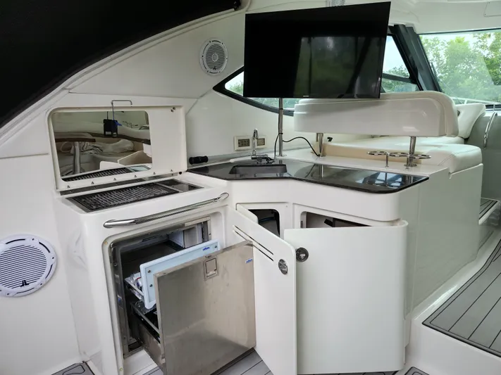 Moonwake Yacht Photos Pics 2014 Sea Ray 470 Sundancer yacht interior with kitchenette, TV, and seating area.