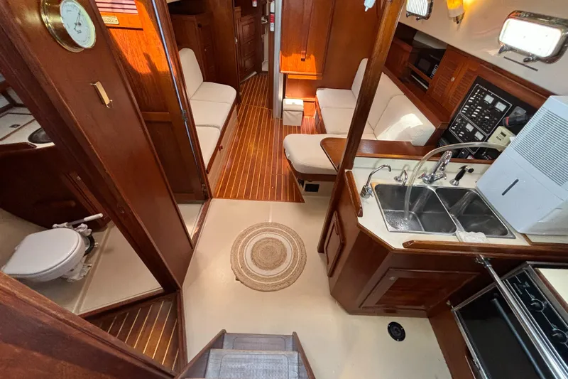Carpe Diem Yacht Photos Pics Interior of 1995 Island Packet 40 sailboat with wood finish and compact kitchen.